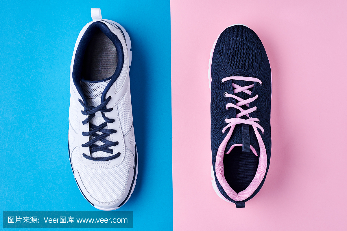 男性和女性的运动鞋在一个柔和的蓝色和粉红色的背景,俯视图。最小的时尚风格